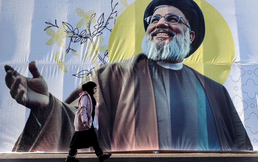 A girl walks past a picture of Hassan Nasrallah on the outskirts of Beirut, Lebanon, Feb. 24, 2025. (Reuters)