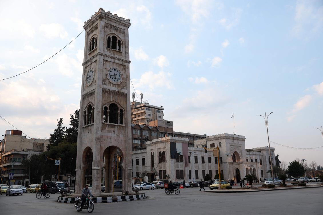 A man drives a bicycle past the landmark clock tower of the central Syrian city of Hama on January 27, 2025. (AFP)
