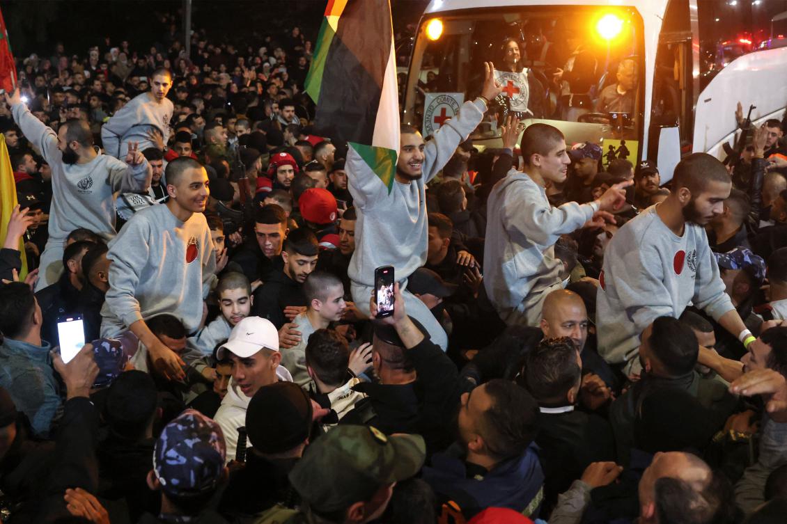 A crowd welcomes Palestinians formerly jailed by Israel as they arrive in a Red Cross convoy to Ramallah in the occupied West Bank on Jan. 30, 2025. (AFP)