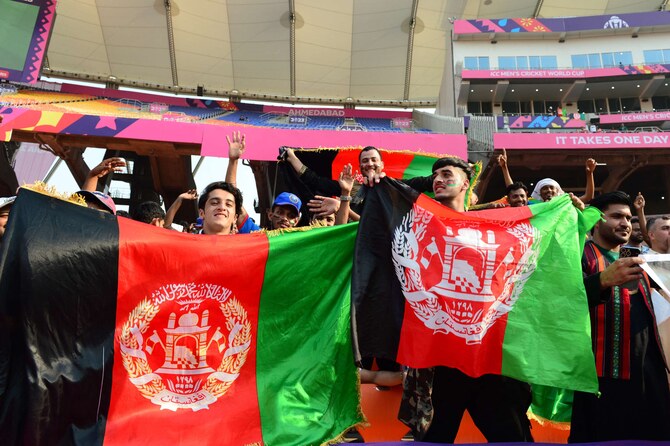 Afghanistan fans hold their national flags as they watch the ICC Men’s Cricket World Cup one-day international (ODI) match between South Africa and Afghanistan in Ahmedabad on November 10, 2023. (AFP/File)