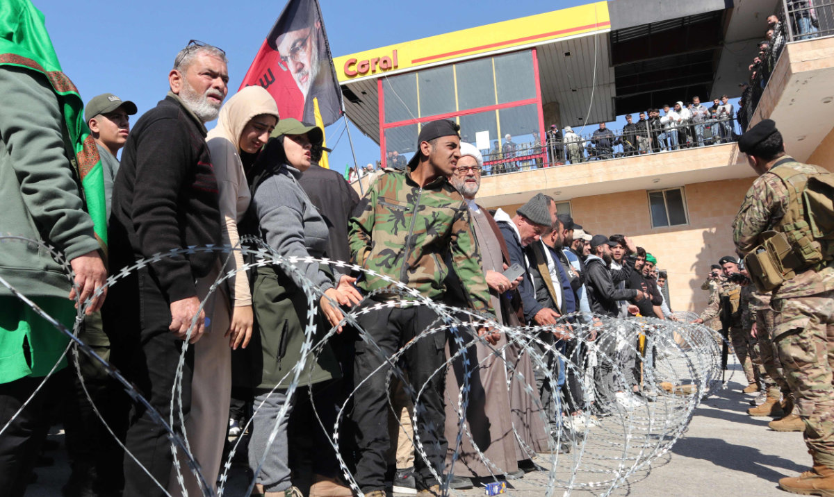 Lebanese army soldiers block residents of the southern Lebanese village Deir Mimas from approaching a roadblock, set up by Israeli soldiers, to stop them from returning to their village on February 2, 2025. (AFP)
