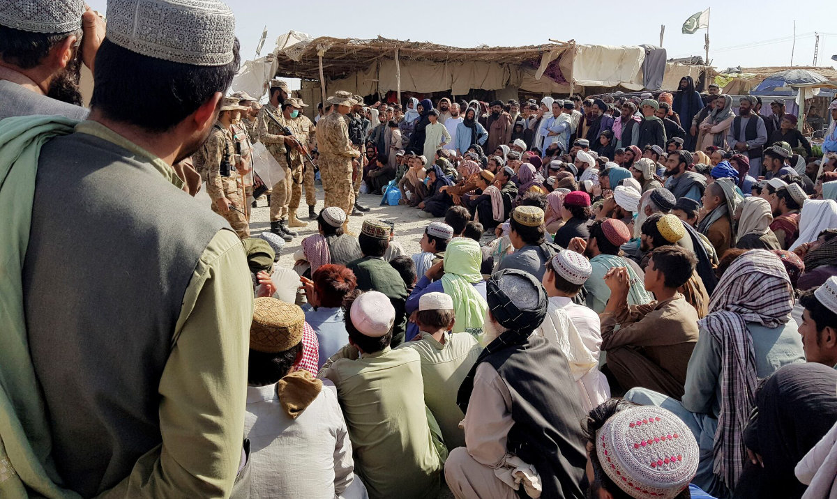 Pakistan's Army soldiers talk with people who gather to cross at the Friendship Gate crossing point in the Pakistan-Afghanistan border town of Chaman, Pakistan August 12, 2021. (Reuters)