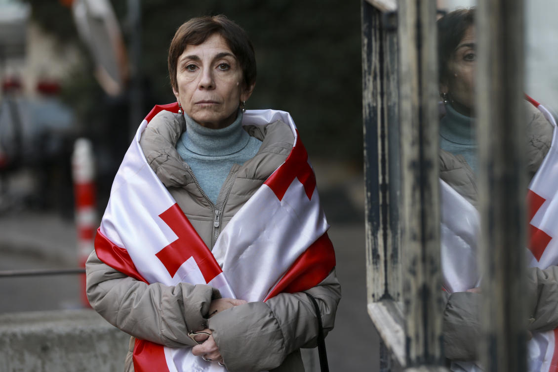 Lika Guntsadze, mother of arrested film and theater actor Andro Chichinadze, drapes herself in a Georgian flag in Tbilisi, Georgia, on Friday, Jan. 31, 2025. (AP)