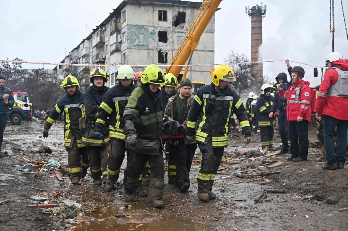 Firefighters carry the body of a civilian following a missile strike in Poltava on Feb. 1, 2025, amid the Russian invasion on Ukraine. (AFP)
