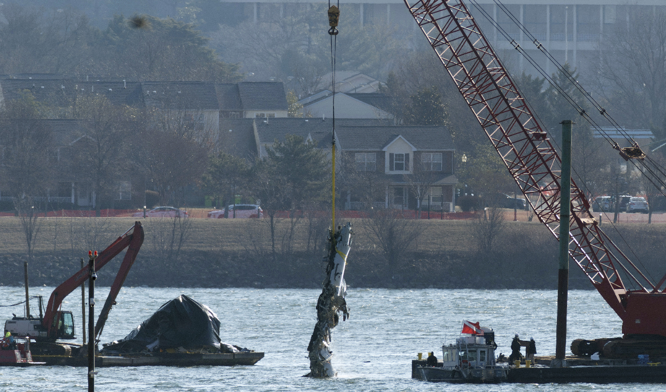 A crane pulls up a portion of the damaged plane during recovery efforts after the American Airlines crash on February 04, 2025 in Arlington, Virginia. (AFP)