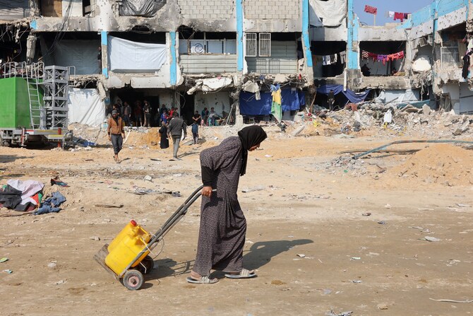 A Palestinian woman pulls a trolley with water cans in Jabalia in the northern Gaza Strip, Feb. 4, 2025. (AFP/File)