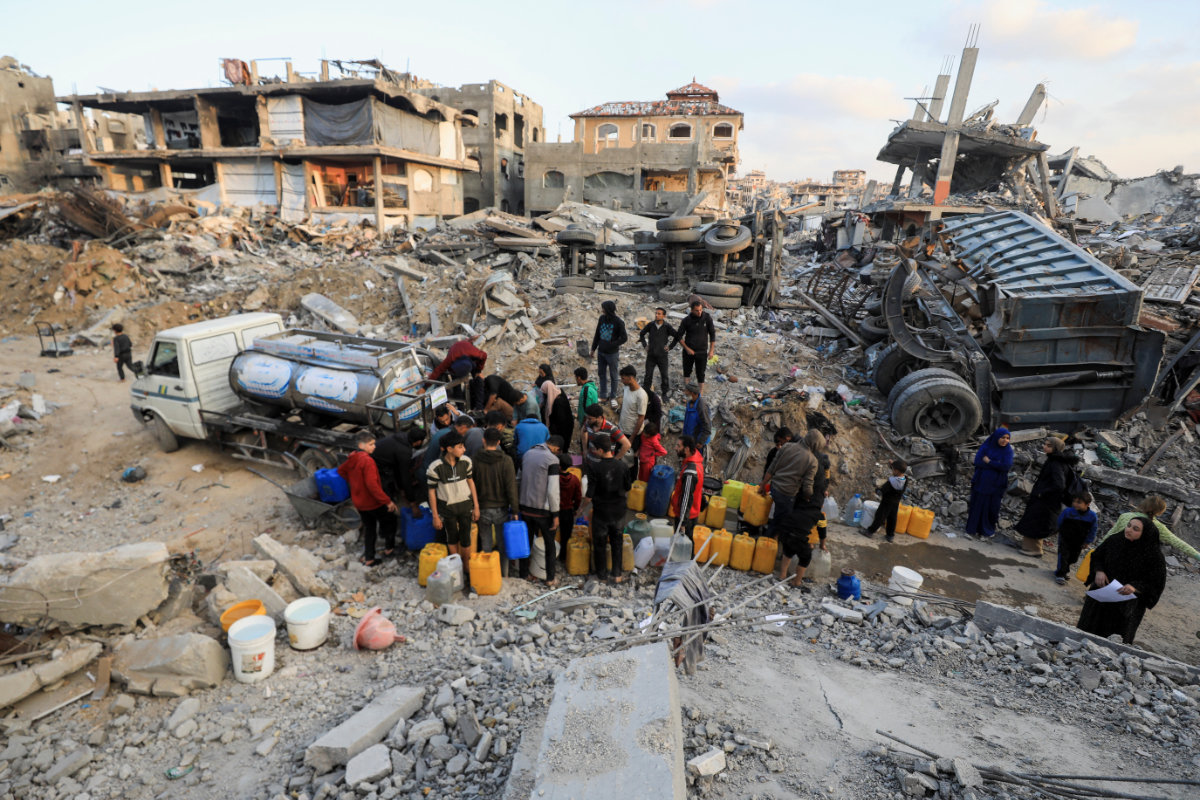 Palestinians fill up containers with water in Jabalia refugee camp in the northern Gaza Strip on February 4, 2025, amid a ceasefire between Israel and Hamas. (Reuters)