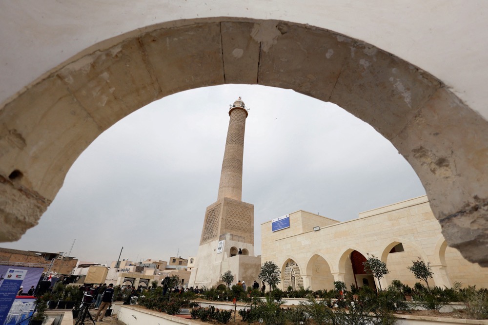 Builders give last touches to the Al-Hadba minaret of Mosul’s Al-Nuri Mosque. The 12th century minaret was destroyed by Daesh in 2017. (Reuters)