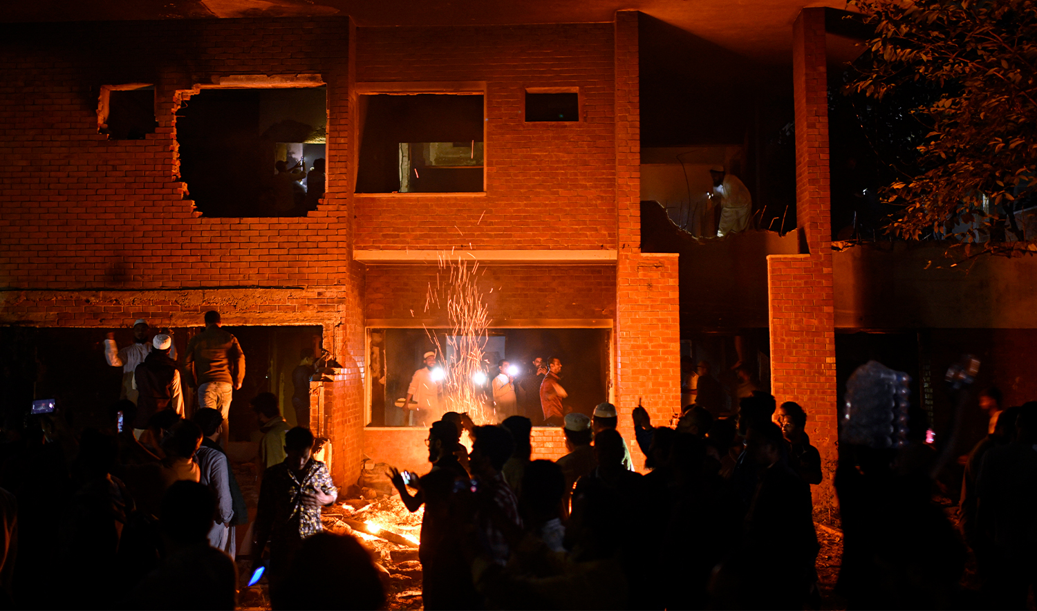 People watch as protesters use heavy machinery to demolish the residence of Sheikh Mujibur Rahman, Bangladesh's former leader and the father of the country's ousted Prime Minister Sheikh Hasina, at Dhanmondi, in Dhaka, Bangladesh, on Feb. 6, 2025. (AP)