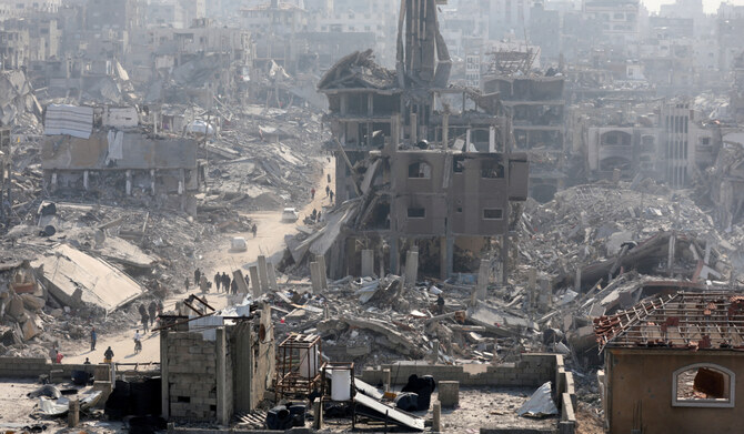 People walk past the rubble of destroyed buildings, in Jabalia, in the northern Gaza Strip, January 30, 2025. (REUTERS)