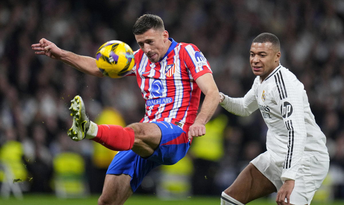 Atletico Madrid's Clement Lenglet clears the ball away from Real Madrid's Kylian Mbappe, right, during a Spanish La Liga soccer match between Real Madrid and Atletico Madrid at the Santiago Bernabeu stadium in Madrid, Saturday, Feb. 8, 2025. (AP)