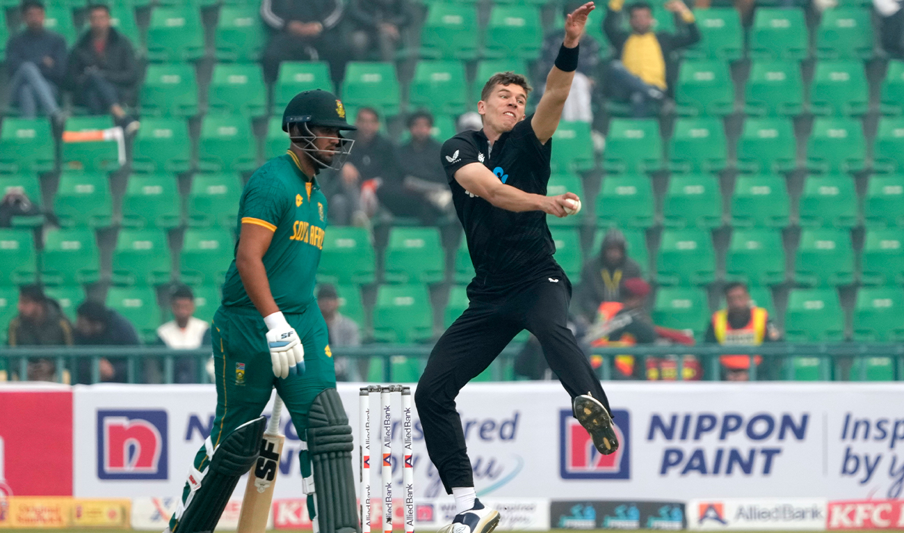 New Zealand's Ben Sears, right, bowls as South Africa's Jason Smith watches during the tri-series ODI cricket match between New Zealand and South Africa, in Lahore, Pakistan, on Feb. 10, 2025. (AP)