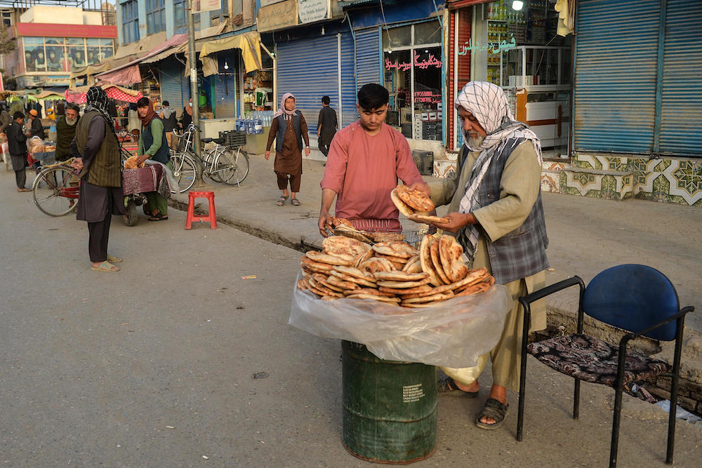 A suicide bomber killed five people including Taliban security forces on Tuesday in an explosion outside a bank in northern Afghanistan. A baker sells bread along a road in Kunduz. (AFP file photo)