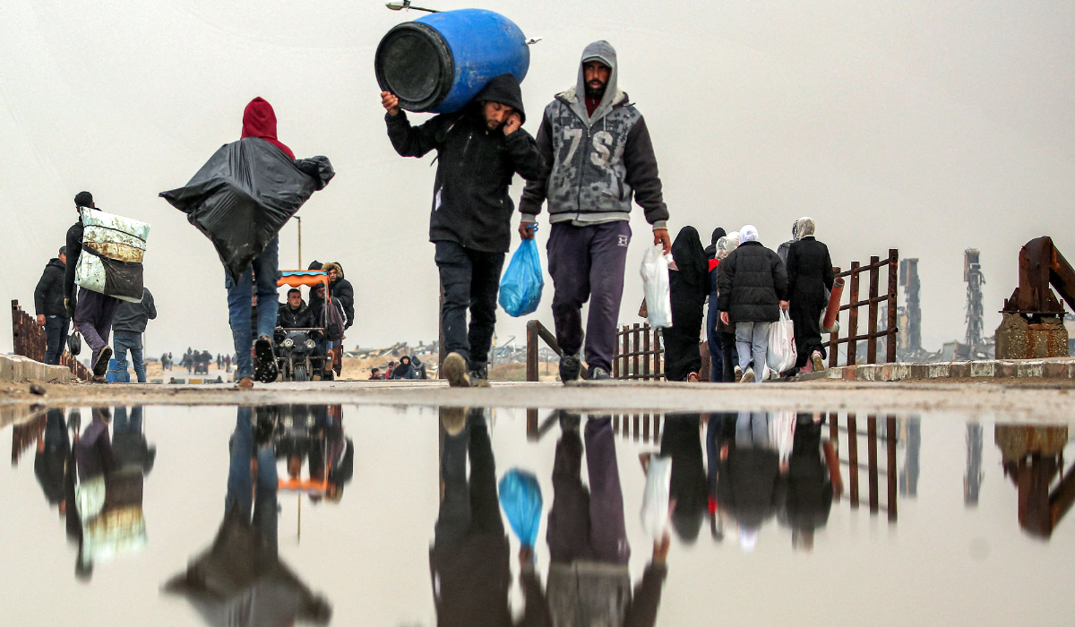 People walk with belongings along the Wadi Gaza bridge along al-Rashid street across between Gaza City and Nuseirat in the central Gaza Strip on February 10, 2025 as displaced people return home amid the current ceasefire deal in the war between Israel and Hamas. (AFP)