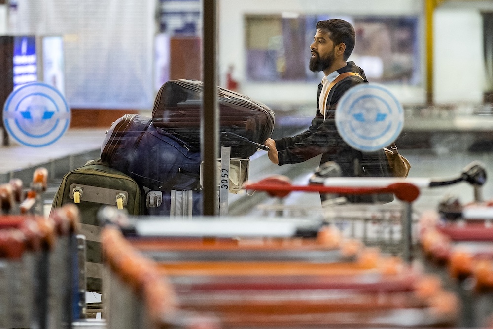 A Bangladeshi national carries luggage on a trolley upon his arrival at the Hazrat Shahjalal International Airport in Dhaka on Oct. 21, 2024. (AFP)