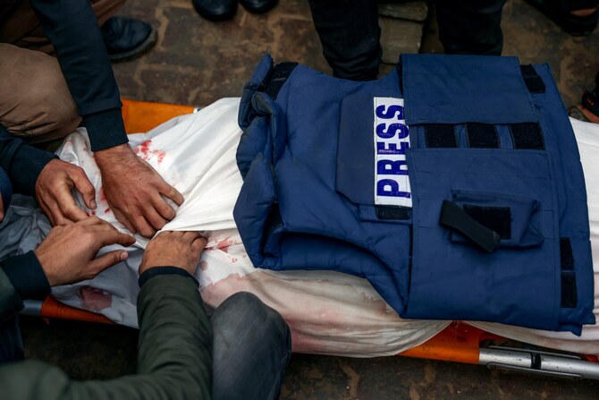 Mourners prepare for burial the body of Palestinian journalist Ahmed Al-Shayah after he was killed during an Israeli strike the previous night in Khan Yunis, at Nasser Hospital, in the southern Gaza Strip, on January 16, 2025. (AFP)