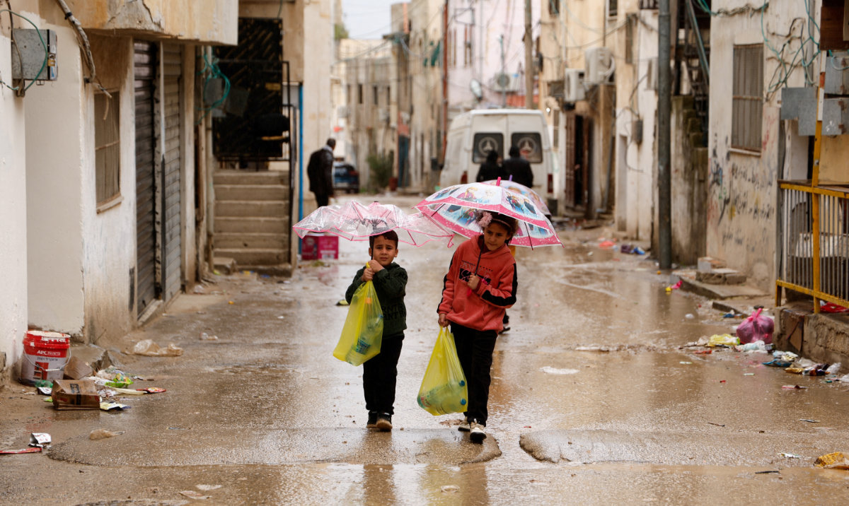 Palestinians children carry bottles of water amid disruption of water supply, in the aftermath of an Israeli raid, in Al-Faraa refugee camp near Tubas, in the Israeli-occupied West Bank, February 12, 2025. (Reuters)