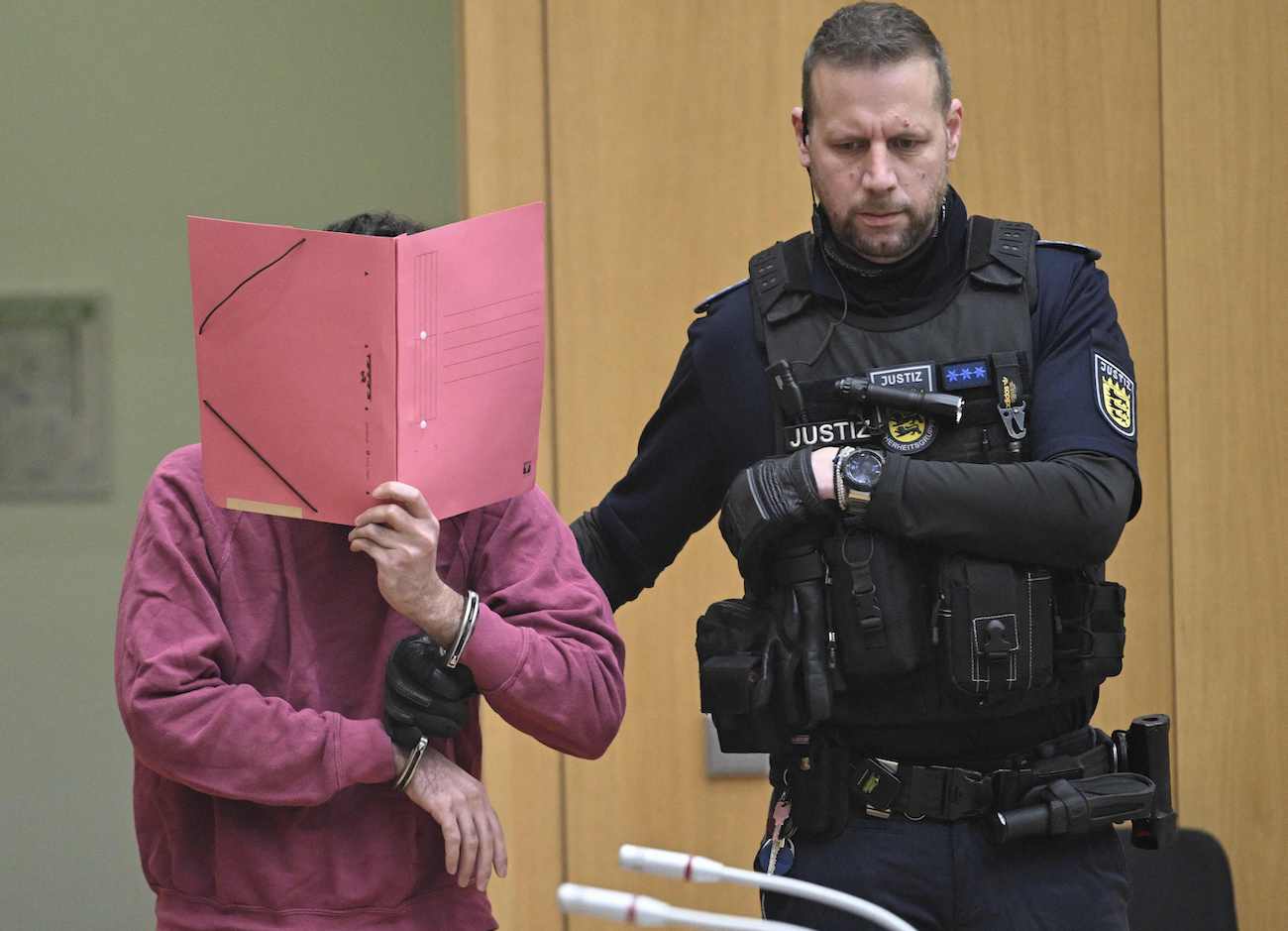 Defendant (L) arrives in the courtroom of the Higher Regional Court in Stuttgart-Stammheim, southern Germany, on February 13, 2025, before the start of his trial. (AFP)