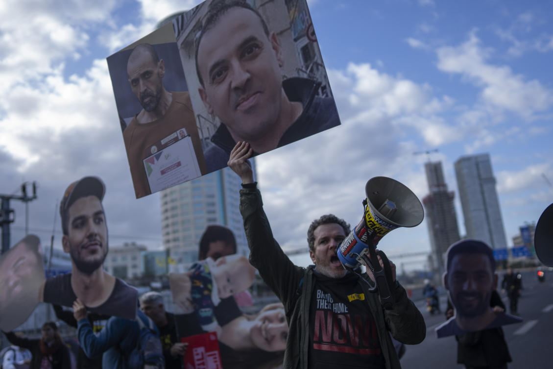 A demonstrator holding photos of freed Israeli hostage Eli Sharabi before and after his captivity blocks a highway during a protest demanding all hostages release from Hamas captivity, in Tel Aviv, Feb. 13, 2025. (AP)