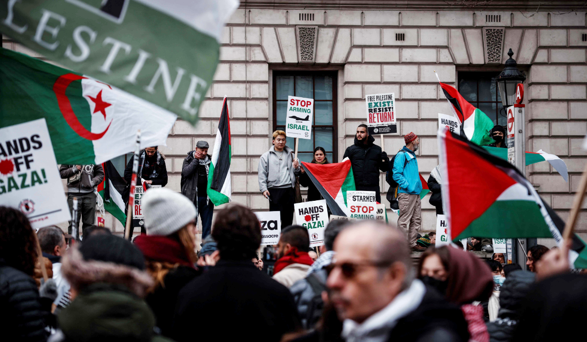 Protesters hold placards and wave Palestinian flags as they take part in a Pro-Palestinian march in central London, on February 15, 2025, organised by the Palestine Solidarity Campaign. (AFP)