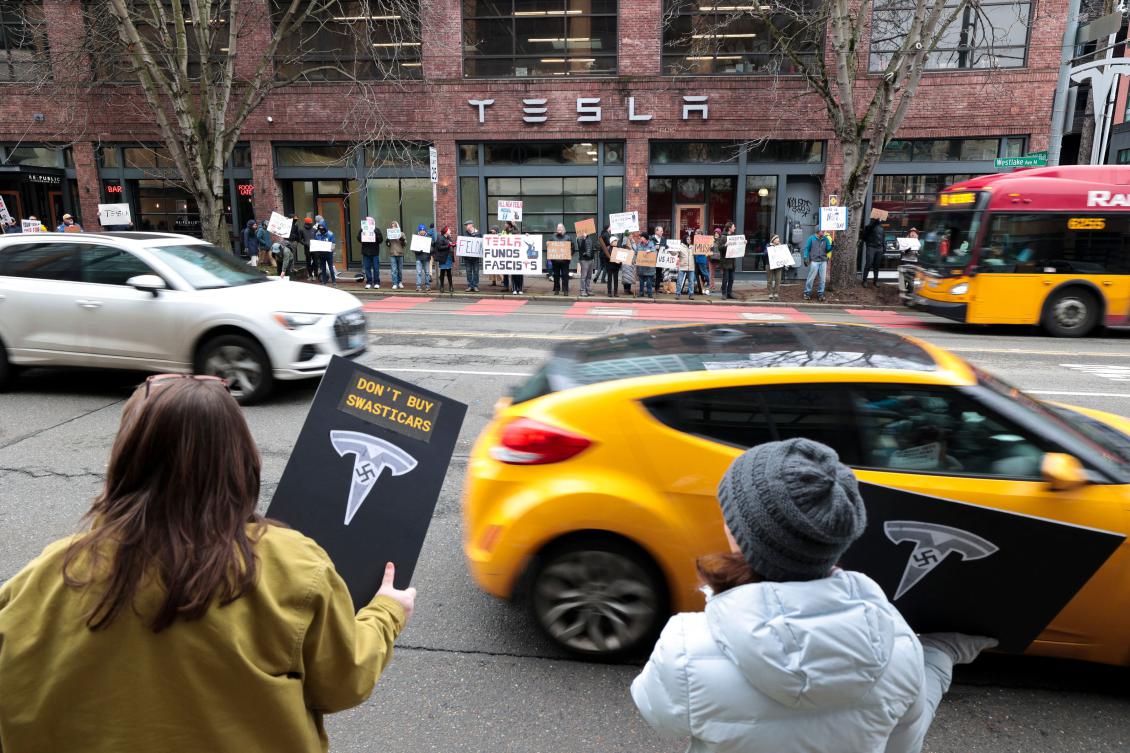 People participate in a "TeslaTakedown" protest against Elon Musk outside of a Tesla showroom in Seattle, Washington, on February 15, 2025. Musk leads the efforts under the newly created Department of Government Efficiency (DOGE), and was speaking at the White House with Trump, who has in recent weeks issued a flurry of orders aimed at slashing federal spending. (AFP)