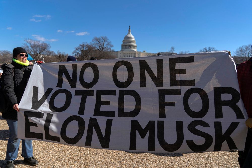 Demonstrators rally during the ‘No Kings Day’ protest on Presidents Day, in support of federal workers and against recent actions by Donald Trump and Elon Musk, Washington, Feb. 17, 2025. (AP Photo)