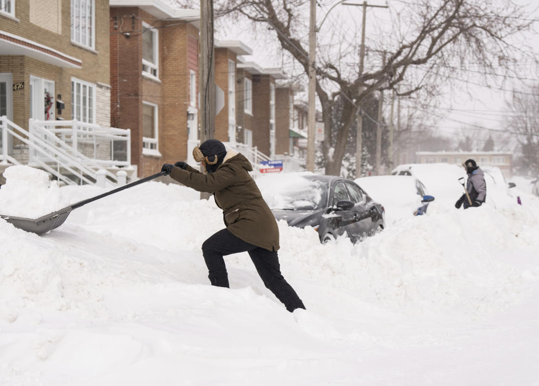 People shovel snow to dig out their cars in Montreal, Monday, Feb. 17, 2025, after over 70 centimeters of snow fell in 4 days, breaking a snowfall record in the city. (AP)