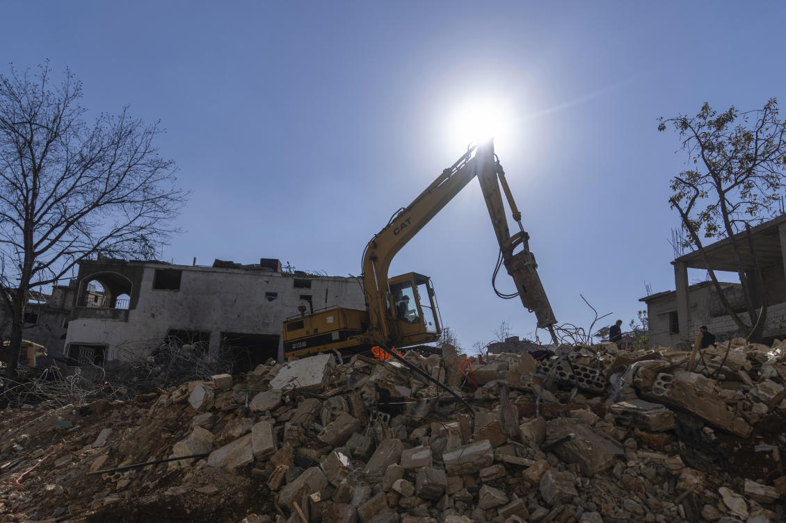 A bulldozer equipped with drill works on the rubble of destroyed houses, caused by the Israeli air and ground offensive, in the town of Khiam, southern Lebanon, Monday, Feb. 17, 2025. (AP)