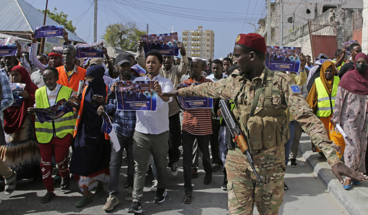 A Somali soldier controls the crowd as people protest over a maritime agreement between Ethiopia and the breakaway region of Somaliland, Mogadishu, Somalia, Jan.3, 2024. (AP Photo)