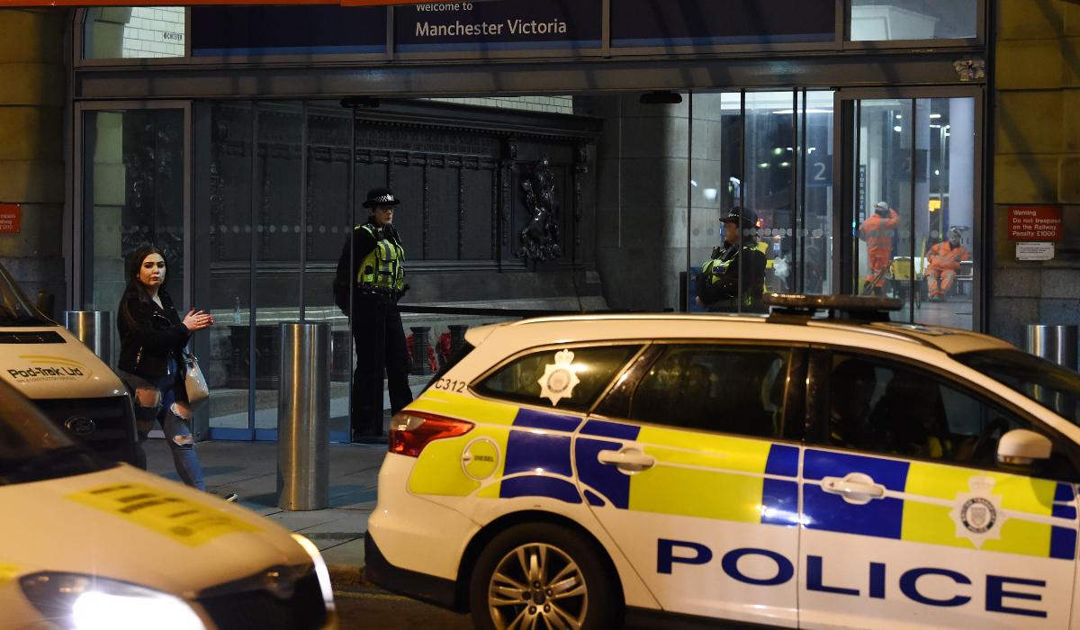 Police officers stand near a cordon at Manchester Victoria Station, in Manchester. (AFP)