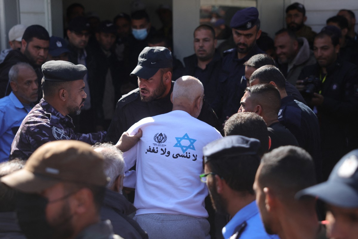A former Palestinian prisoner, released as part of the sixth hostage-prisoner exchange and wearing a sweatshirt featuring the prison service logo, a Star of David, and the slogan: "We do not forget and we do not forgive" (AFP)