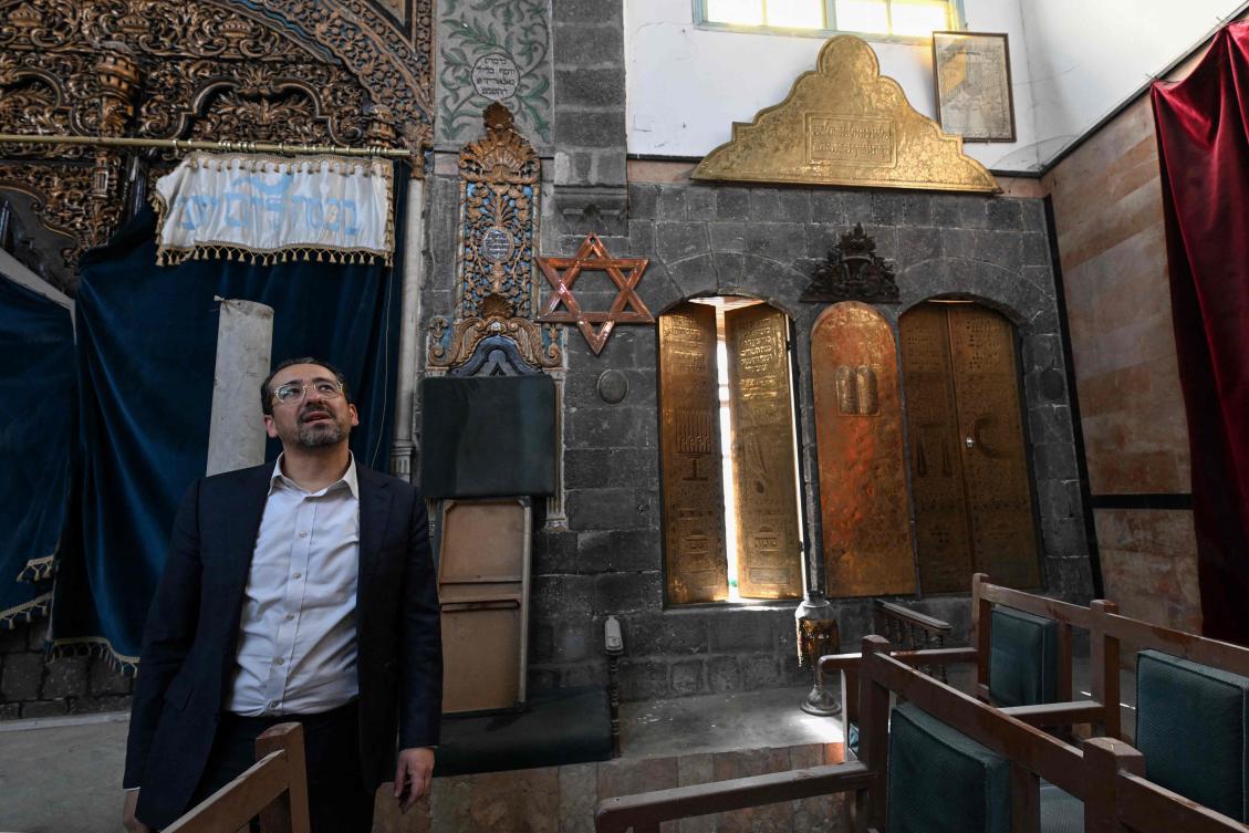 Henry, the son of US-based Syrian rabbi Youssef Hamra (not pictured), tours the Ifrange synagogue in the Jewish quarter in Old Damascus' Bab Sharqi neighbourhood on February 18, 2025 during a visit from the United States. (AFP)