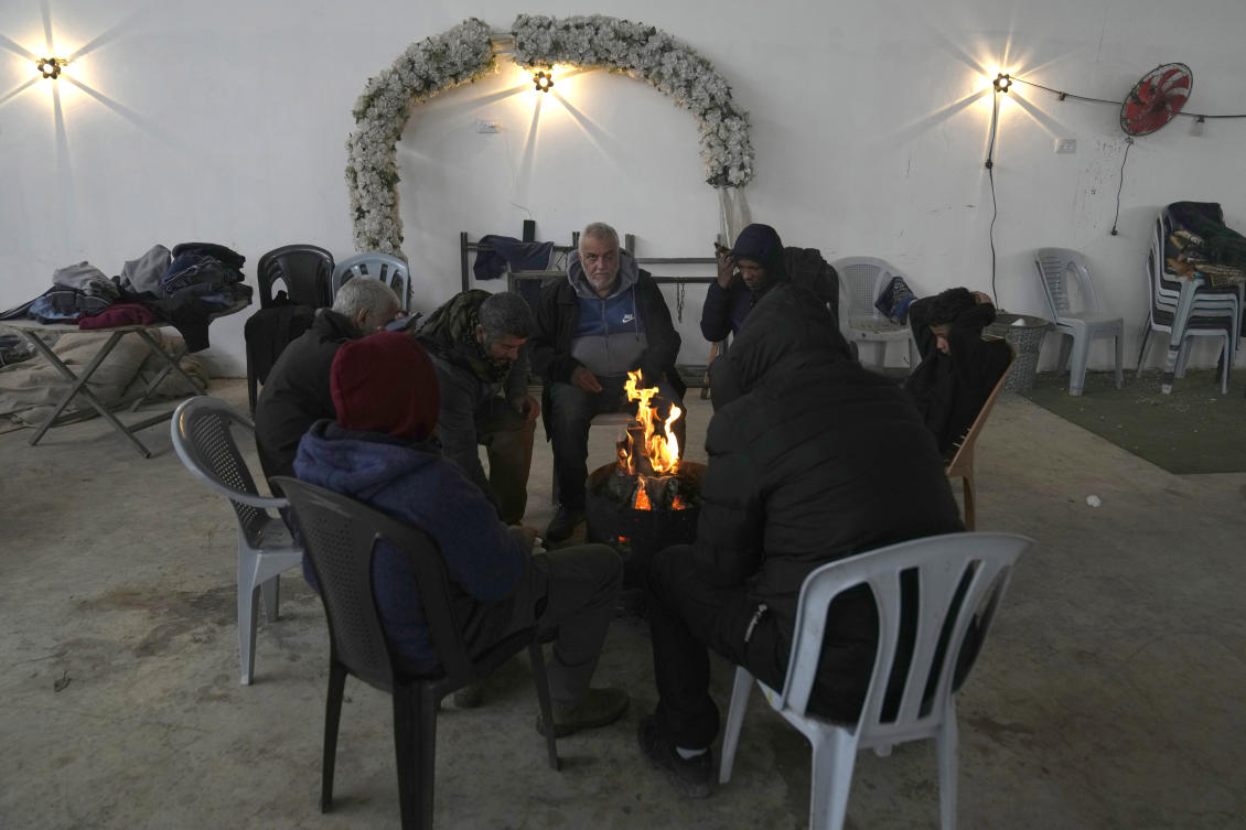 Palestinians who fled the Israeli army operation in the Nur Shams refugee camp, gather around the fire for warmth at a temporary shelter for displaced people in the West Bank town of Anabta, near Tulkarem, Feb. 10, 2025. (AP)