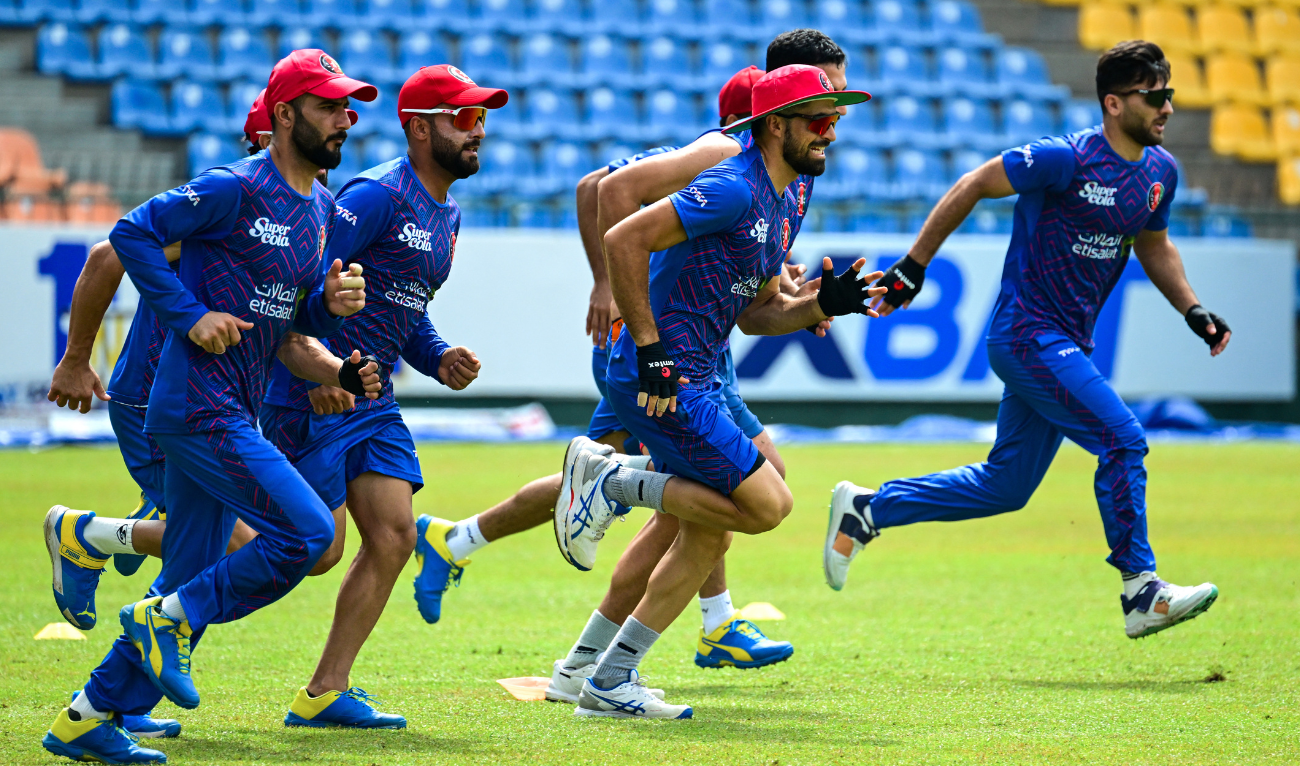 Afghanistan's captain Hashmatullah Shahidi (2L) with teammates warms up during a practice session on the eve of their third and final one-day international (ODI) cricket match against Sri Lanka at the Pallekele International Cricket Stadium in Kandy on February 13, 2024. (AFP/File)