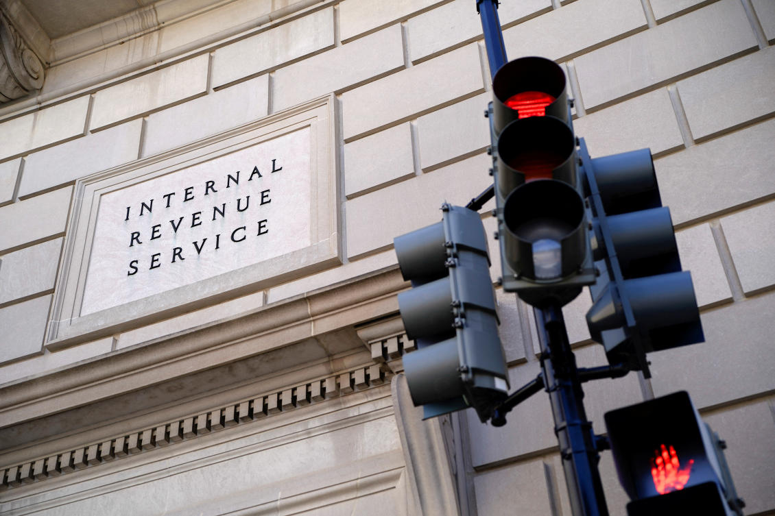 A traffic light is red outside the U.S. Internal Revenue Service (IRS) building after it was reported the IRS will lay off about 6,700 employees, a restructuring that could strain the tax-collecting agency's resources during the critical tax-filing season, in Washington, D.C. (Reuters)