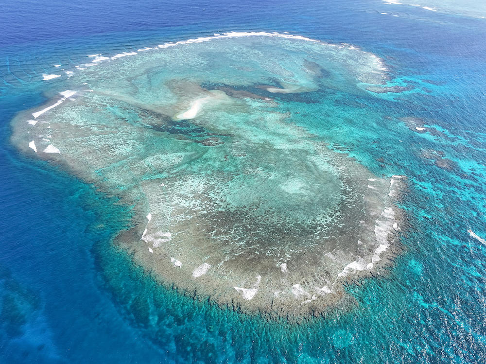 Above, an aerial view of a cay near the Philippine-held Thitu Island, in the Spratly Islands on March 23, 2024. (PCG/BFAR via AFP)