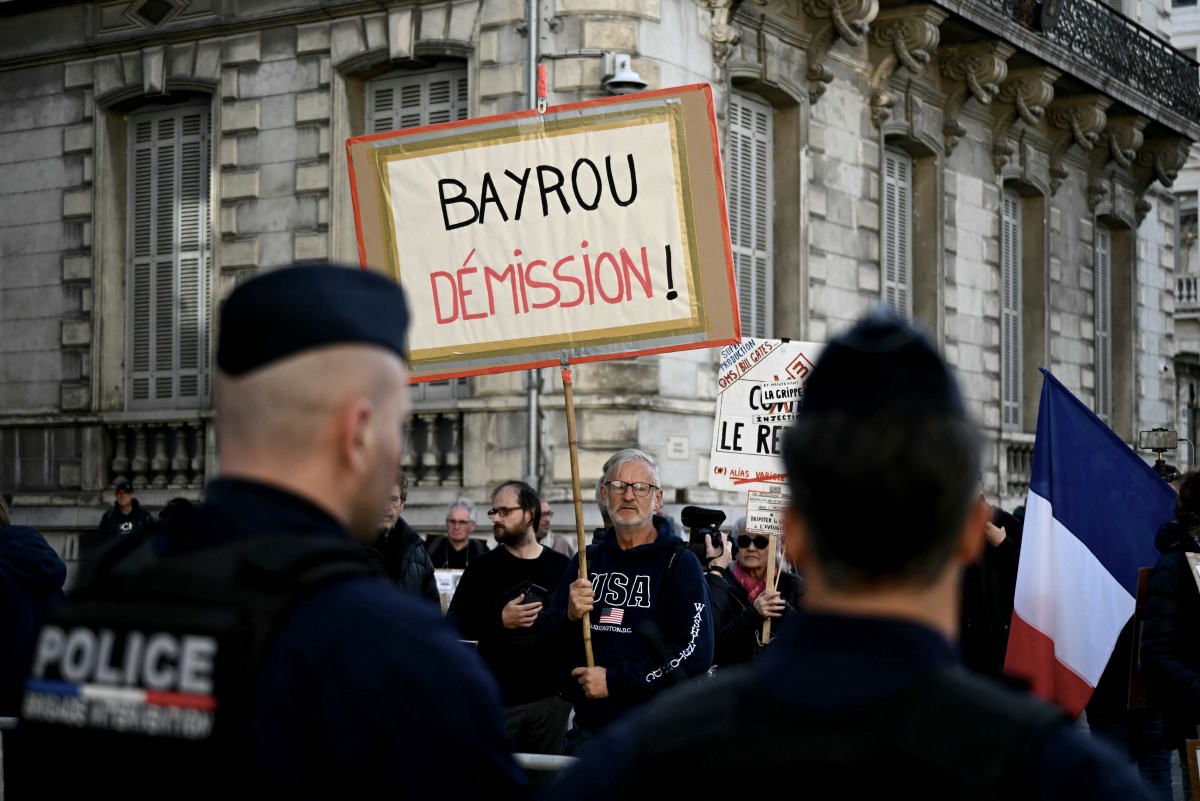 Protesters stand outside the city hall before a meeting of France's Prime Minister Francois Bayrou and members of the collective of victims of violence of the Notre-Dame-de-Betharram Catholic secondary school (AFP)