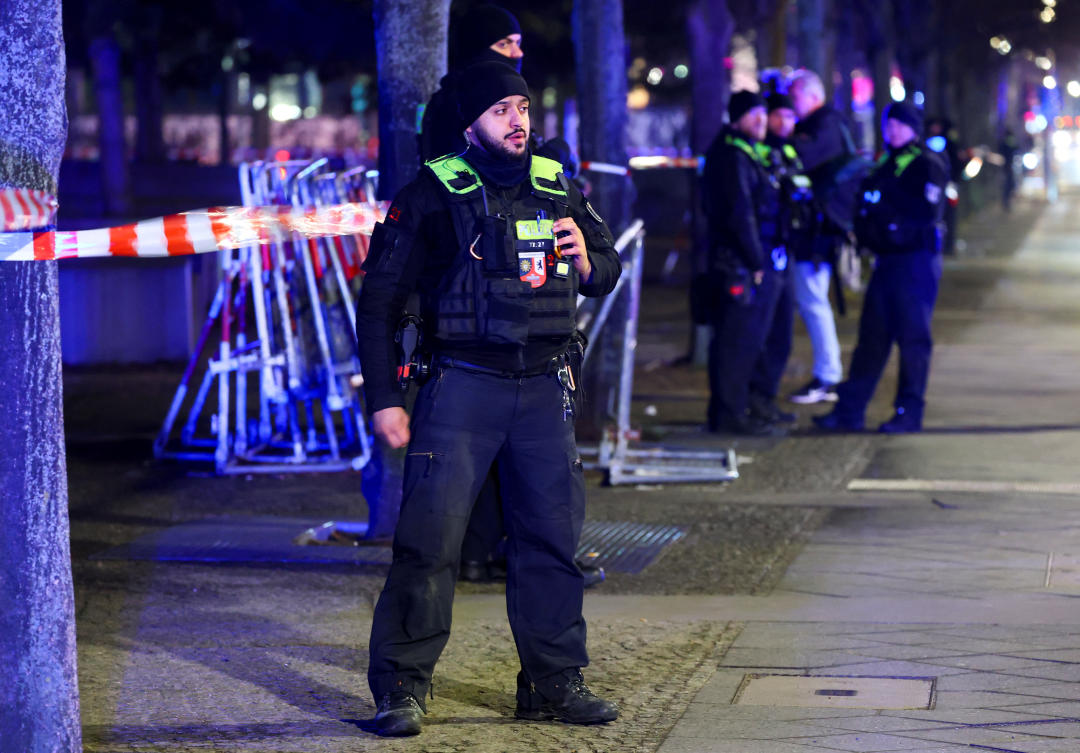 Police officers stand guard after a suspected knife attack at the Holocaust Memorial, according to local media, in Berlin, Germany, February 21, 2025. REUTERS/Fabrizio Bensch