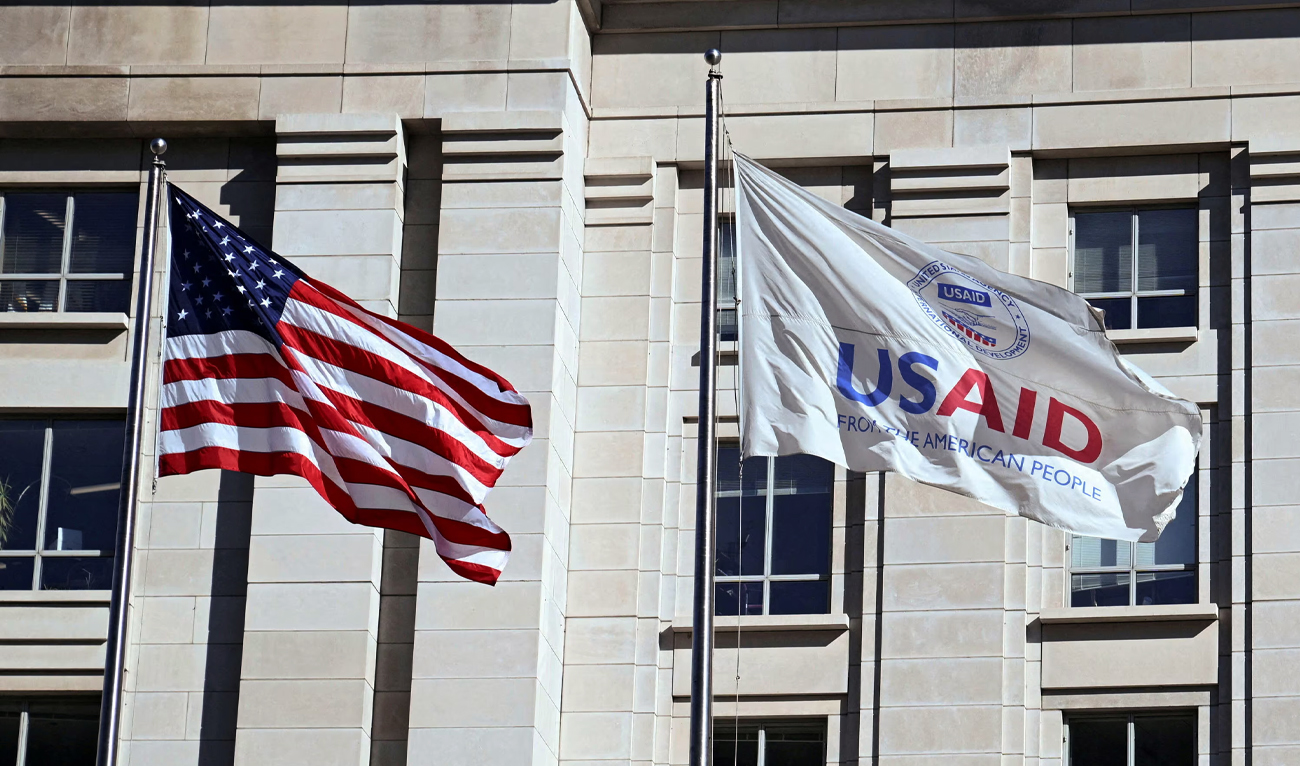 An American flag and USAID flag (right) fly outside the USAID building in Washington, United States, on February 1, 2025. (REUTERS/File)