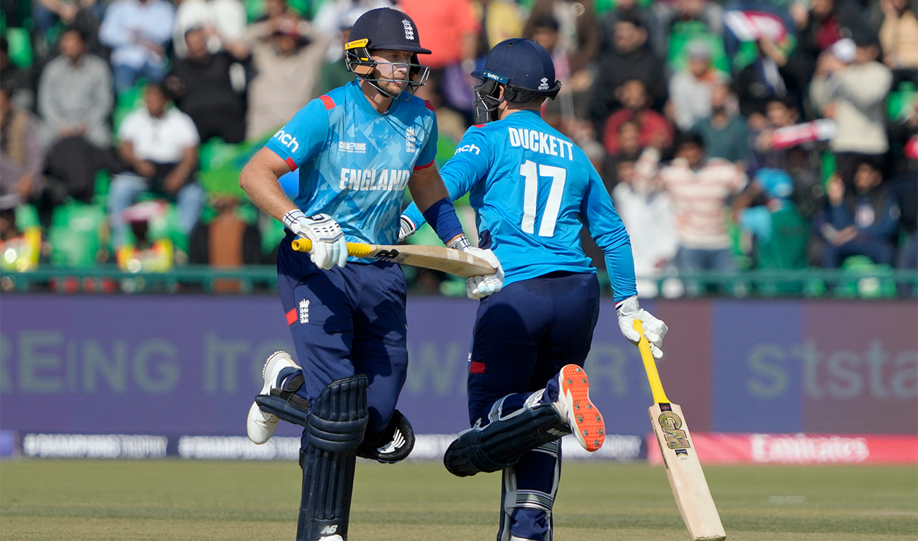 England’s Joe Root (left) and Ben Duckett run between the wickets for scoring during the ICC Champions Trophy cricket match between Australia and England, in Lahore, Pakistan, on February 22, 2025. (AP)