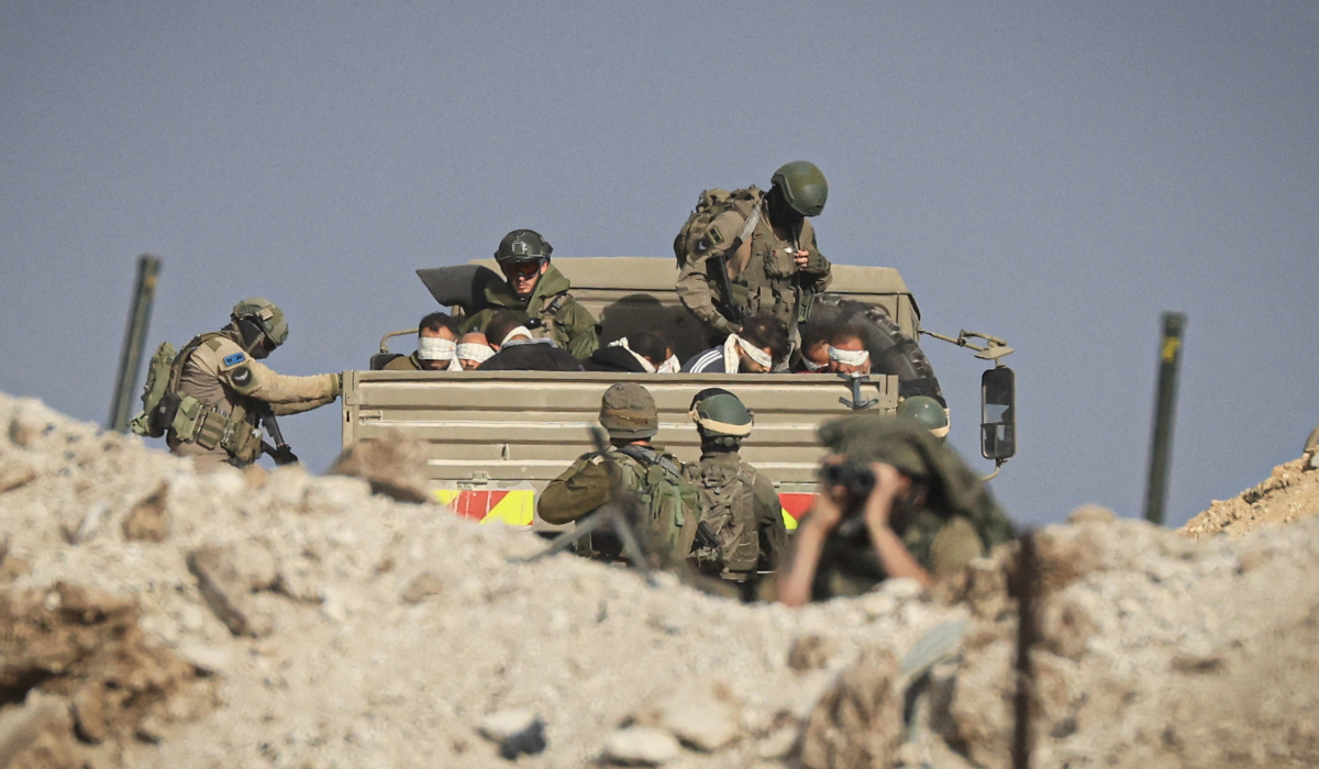 Israeli soldiers detain blindfolded Palestinian men in a military truck in the Zeitoun district of the southern part of the Gaza Strip on Nov. 19, 2023. (AFP file photo)