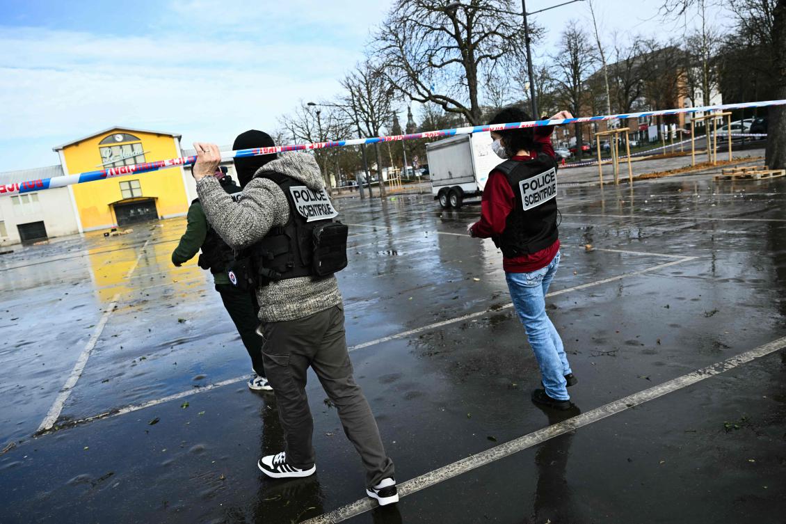 French forensic police walk under police caution tape as they arrive to collect evidence at the site of a bladed weapon attack where a man is suspected of killing one person and wounding two municipal police officers in Mulhouse, eastern France on February 23, 2025. (AFP)