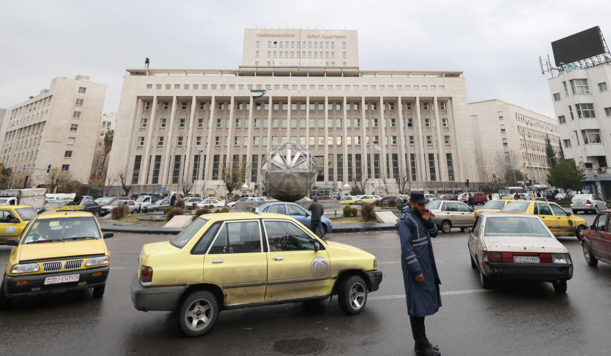 A Syrian officer directs traffic past the Central Bank building in Sabaa Bahrat Square in the capital Damascus on December 29, 2024. (AFP)
