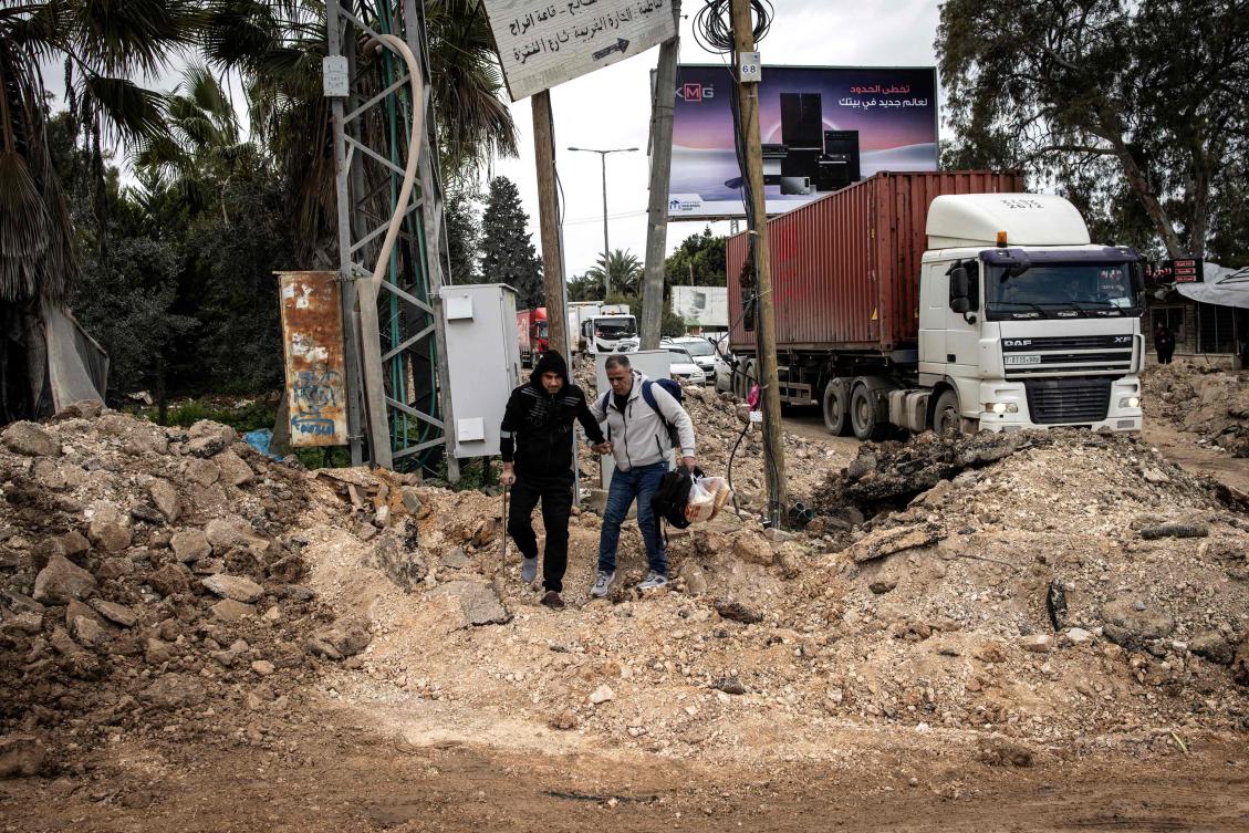 Above, a man on crutches is helped along a road destroyed by Israeli forces at the entrance to the occupied-West Bank city of Qabatiya, north of Jenin on Feb. 24, 2025. (AFP)