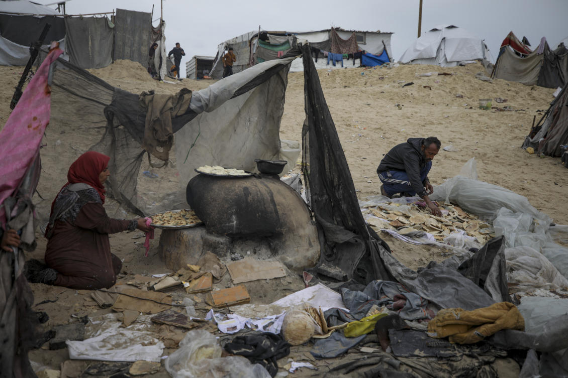Mona Al-Zebda, displaced from Gaza City, bakes bread at a tent camp for displaced Palestinians at the Muwasi, Rafah, southern Gaza Strip, Monday, Feb. 24, 2025. (AP)