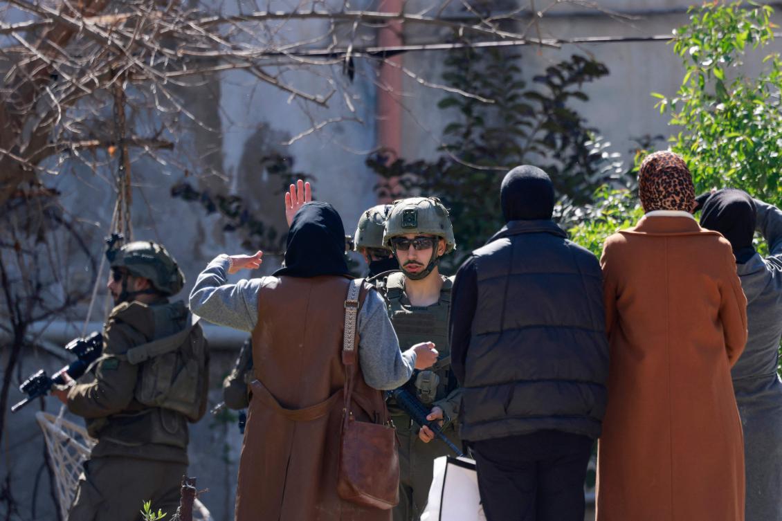 Israeli soldiers prevent displaced Palestinian women from returning to their homes to retrieve belongings amid an offensive of the Israeli military at the Jenin refugee camp in the occupied West Bank on February 25, 2025. (AFP)