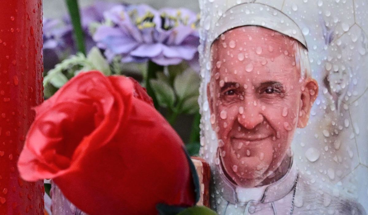 A candle depicting Pope Francis is placed at the statue of John Paul II outside the Gemelli hospital where Pope Francis is hospitalized in Rome on February 25, 2025. (AFP)