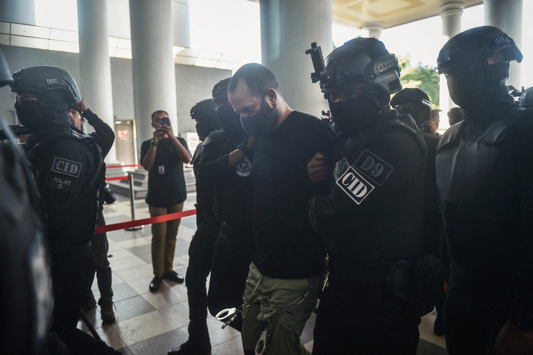 An Israeli man identified as Shalom Avitan (C) is escorted by Malaysian police upon his arrival at a court to face charges of possessing six handguns and 200 bullets in Kuala Lumpur (AFP)