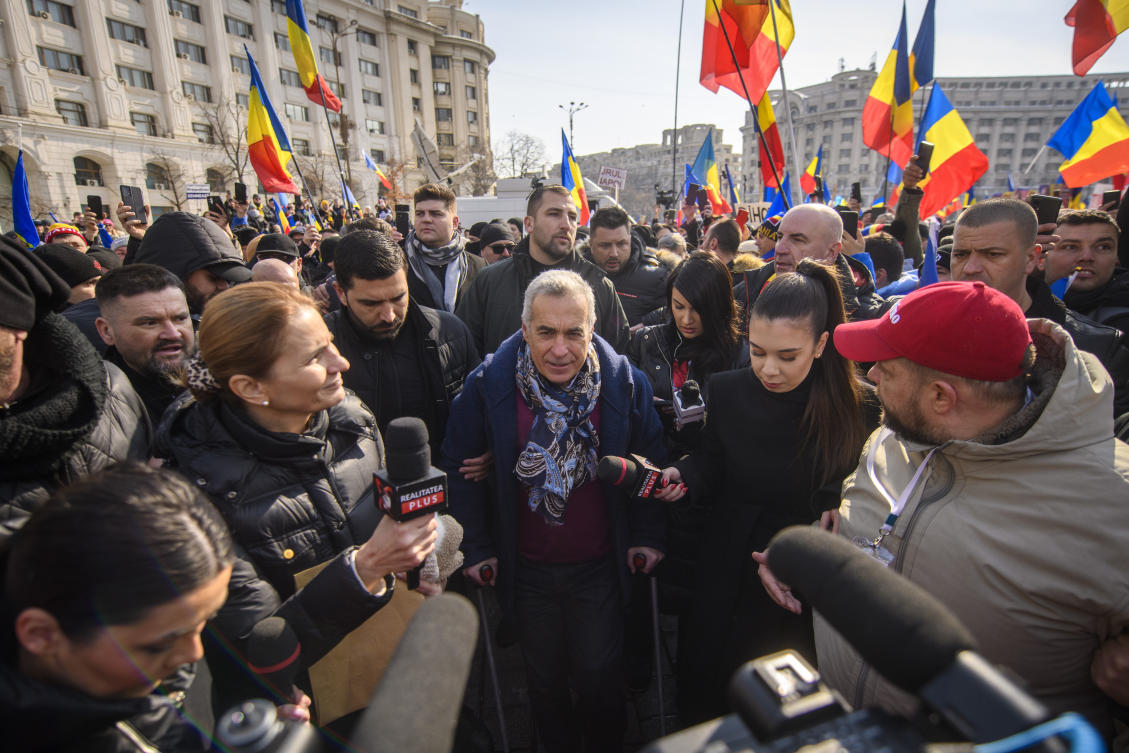 Calin Georgescu, the winner of Romania’s first round of presidential election, annulled by the Constitutional Court, uses crutches walking between supporters gathered for a protest outside the Romanian parliament in Bucharest, Romania, Feb. 22, 2025. (AP)