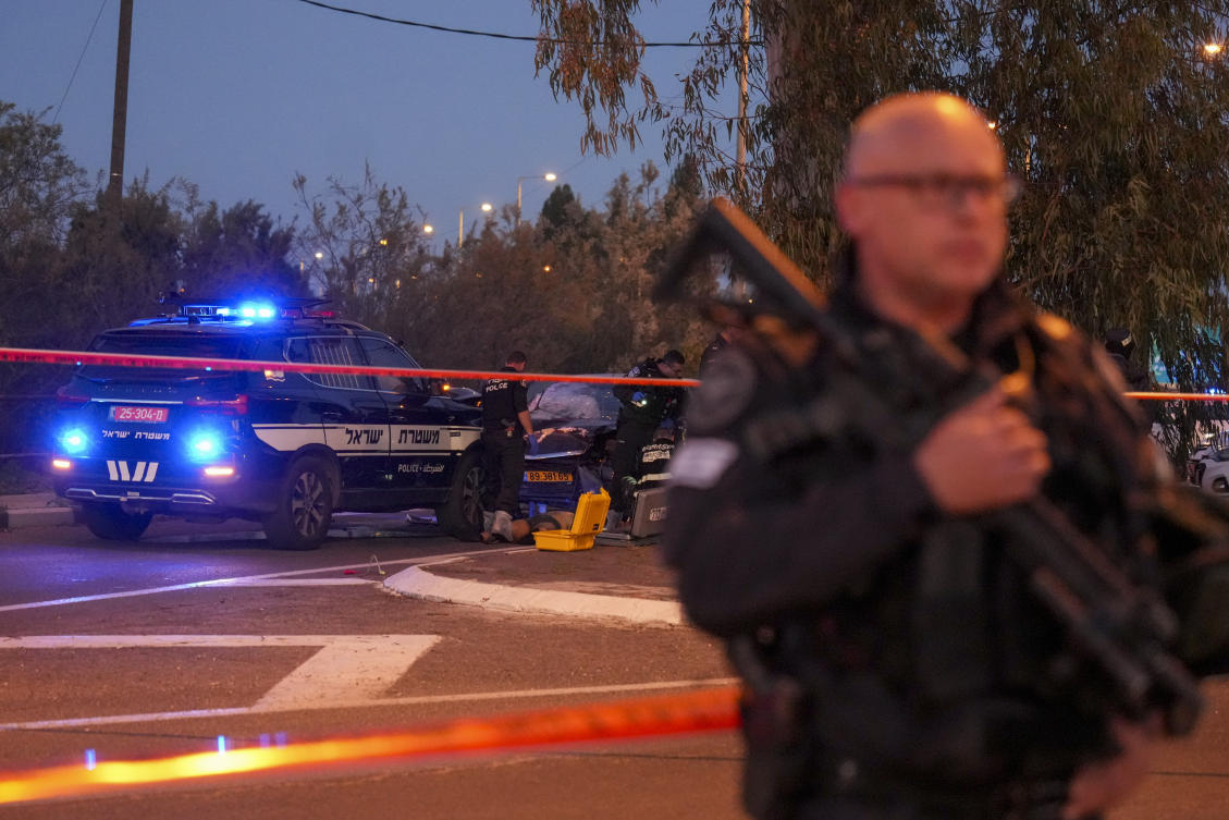 Israeli police officers examine the body of a man suspected of ramming his car into a highway bus stop, injuring several people, Feb. 27, 2025. (AP)